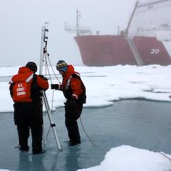 Three men working on equipment in arctic