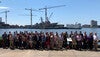 Large group of people in front of ship in harbor